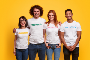 Four people wearing white shirts with the word volunteer